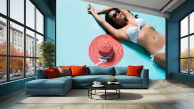 Beautiful asian woman wearing bikini in sunbathing in a studio Wall mural