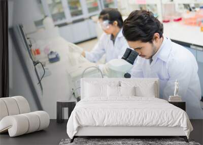 group of scientists working at the laboratory .she use microscop Wall mural