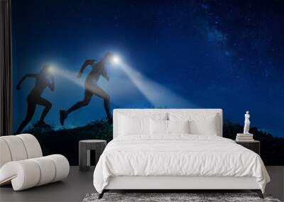 Night trail runner of men and women running on the mountain.at night milky way Wall mural