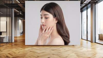 The face of a beautiful asian woman She is touching her cheeks Wall mural