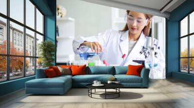 Attractive young Asian scientist woman lab technician assistant analyzing sample in test tube at laboratory. Medical, pharmaceutical and scientific research and development concept. Wall mural