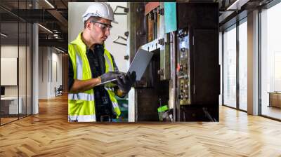 Caucasian engineer mechanic man checking for maintenance pressing metal machine by laptop at factory, worker at industrial concept	 Wall mural