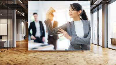 Strong attractive businesswoman show her power with blur business man background at office. Confidence leader in job and management concept. Wall mural