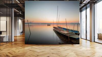 Two small boats moored on the shore of the lake. at sunset beautiful light Wall mural