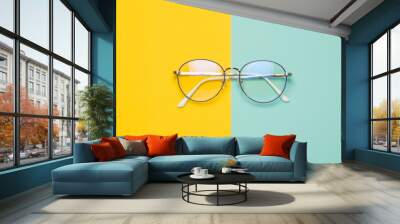 Eye glasses isolated on yellow and blue background. Wall mural