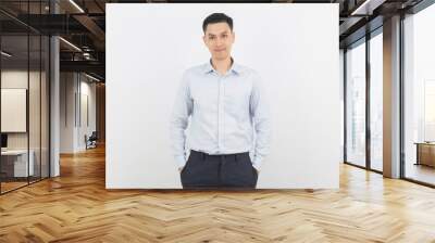 Young handsome asian business man looking to camera with arms crossed isolated on white background. Wall mural