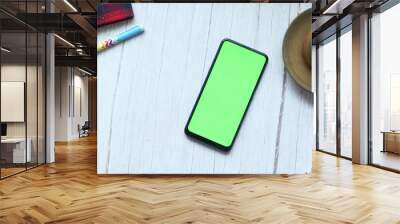  smart phone with empty screen, tea, notepad on wooden table  Wall mural