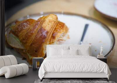 A Freshly Baked Croissant is beautifully presented with a Fork on a Plate, inviting to eat Wall mural