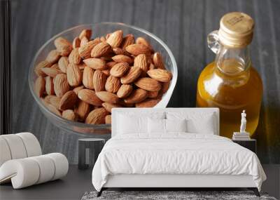 almond nuts in a bowl and oil in a jar on table  Wall mural