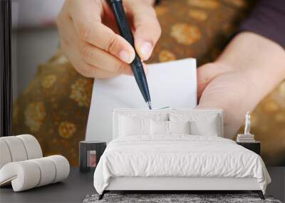 women hand writing goals on a notepad  Wall mural