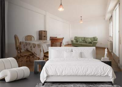 Living room of a house with a wooden dining table with a vinyl tablecloth, wooden chairs, oak parquet floors Wall mural