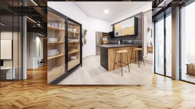 Modern style kitchen with wooden furniture combined with black, a counter with stools and a sideboard for dishes with sliding glass doors Wall mural