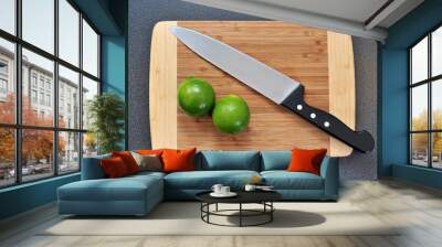 Two whole limes on a kitchen table Wall mural