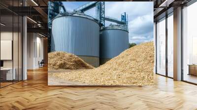 A modern agricultural facility featuring large silos and mounds of harvested grains under a cloudy sky. Wall mural