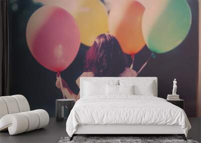 A young girl with long hair holds colorful balloons, radiating joy and innocence. soft focus and pastel colors create whimsical atmosphere, perfect for capturing childhood moments Wall mural