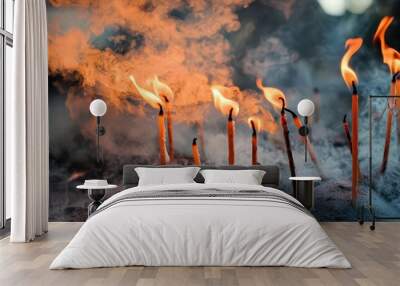 Incense sticks burn brightly, emitting smoke and flame, creating an atmosphere of spirituality and reflection. Wall mural