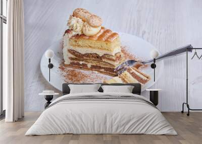 Tiramisu cake/ dessert with fork, cacao on a porcelain plate Wall mural