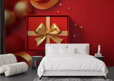 Festive gift box with gold ribbon on red background decorated with ornaments. Wall mural