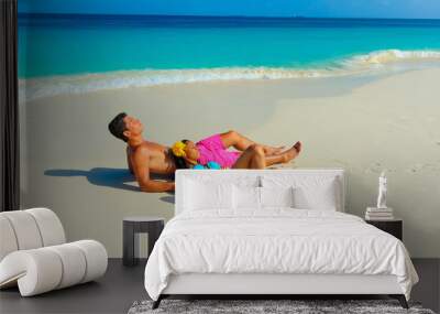 Couple at the beach sitting on the sand relaxing, interracial, black Wall mural