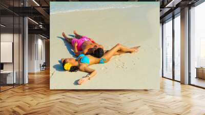 Couple at the beach sitting on the sand relaxing, interracial, black Wall mural