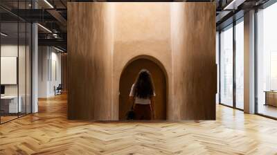 Stunning view of a girl visiting the Bahia Palace during a sunny day. The Bahia Palace in Marrakech is an impressive example of Moroccan architecture and design. Wall mural