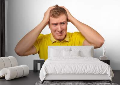 Upset young male in yellow T-shirt clutched at head, forgetful man, isolated on white background Wall mural