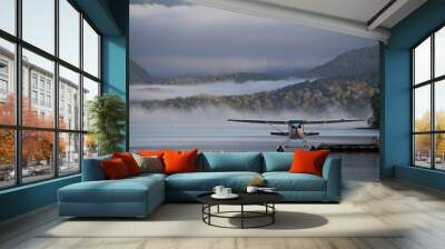 A landed waterplane - in the foggy hills Wall mural