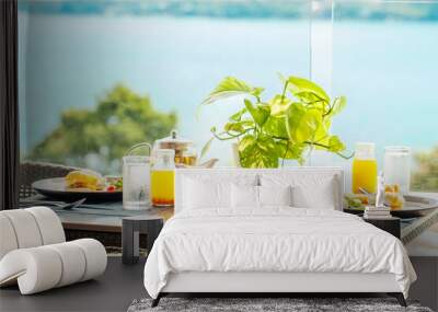 Outdoor healthy breakfast for two with a sea view: avocado toast, orange juice, coffee, eggs, granola served on a table. Hotel or resort breakfast buffet concept. Wall mural