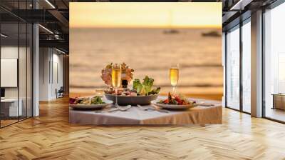 Romantic sunset dinner on beach. Table honeymoon set for two with luxurious food, glasses of champagne drinks in restaurant with sea view and yachts on background. Summer vacation or wedding concept. Wall mural