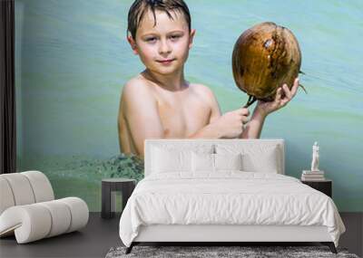 boy is playing with a coconut on a beautiful beach Wall mural