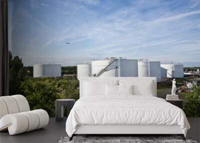 white tanks in tank farm with blue sky and aircraft Wall mural