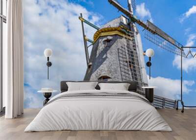 Windmill in rural landscape with blue and cloudy sky Wall mural