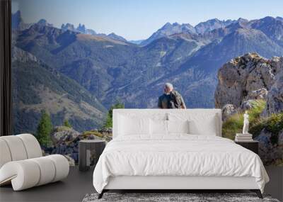 Active senior man hiking in Dolomiti mountains with backpack, enjoying his adventure. Carezza, Dolomites Alps, South Tyrol, Italy, Europe. Wall mural