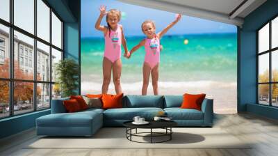 Adorable little girls having fun during beach vacation Wall mural