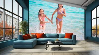 Adorable little girls having fun on the beach Wall mural