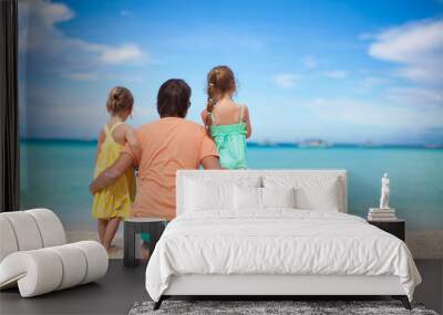 Back view of happy father with his two daughters on tropical Wall mural