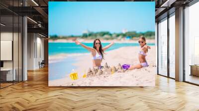 Beautiful mother and daughter on the beach enjoying summer vacation Wall mural