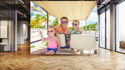 Dad and his little girls driving golf cart on tropical beach Wall mural