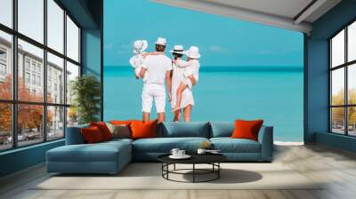 Happy beautiful family of four on the beach Wall mural