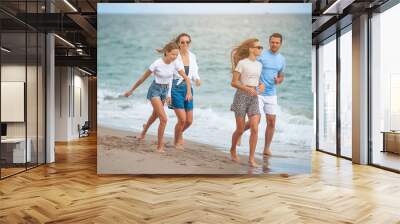 Happy family on the beach during summer vacation Wall mural