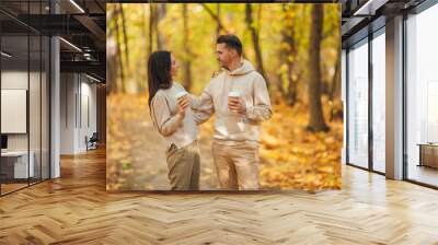 Happy family walking in autumn park on sunny fall day Wall mural