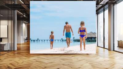 Happy father and his adorable little daughters at tropical beach having fun Wall mural