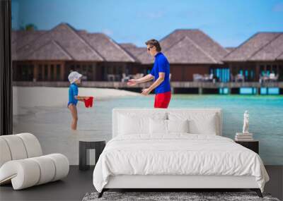 Happy father and little daughter have fun on tropical beach Wall mural