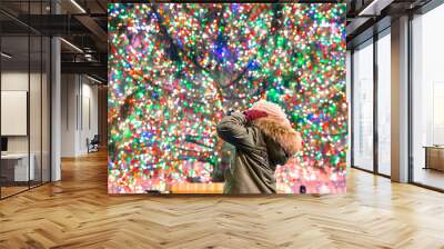 Happy girl on the background of the Rockefeller Christmas tree in New York Wall mural