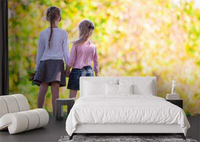 Little adorable girls outdoors at warm autumn day Wall mural