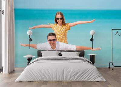 Little girl and happy dad having fun during beach vacation Wall mural