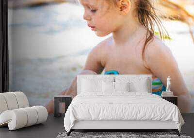 Little girl at tropical white beach making sand castle Wall mural