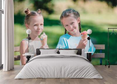 Little girls eating ice-cream outdoors at summer in outdoor cafe Wall mural