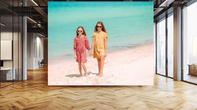 Little happy funny girls have a lot of fun at tropical beach playing together. Wall mural