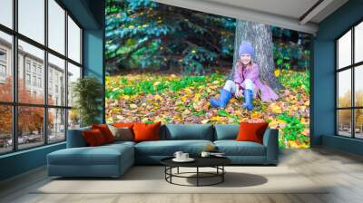 Little happy girl in autumn park on sunny fall day Wall mural